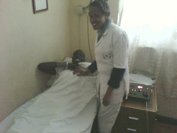 A Nurse Standing Beside a Man on a Bed