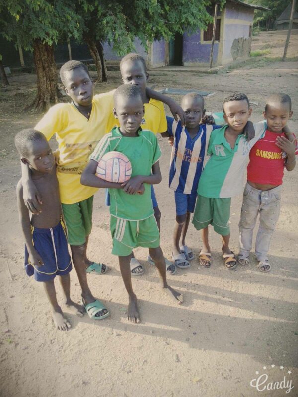 A group of boys posing for a picture with a Soccer Ball.